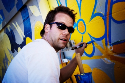 Adam Turman painting a mural